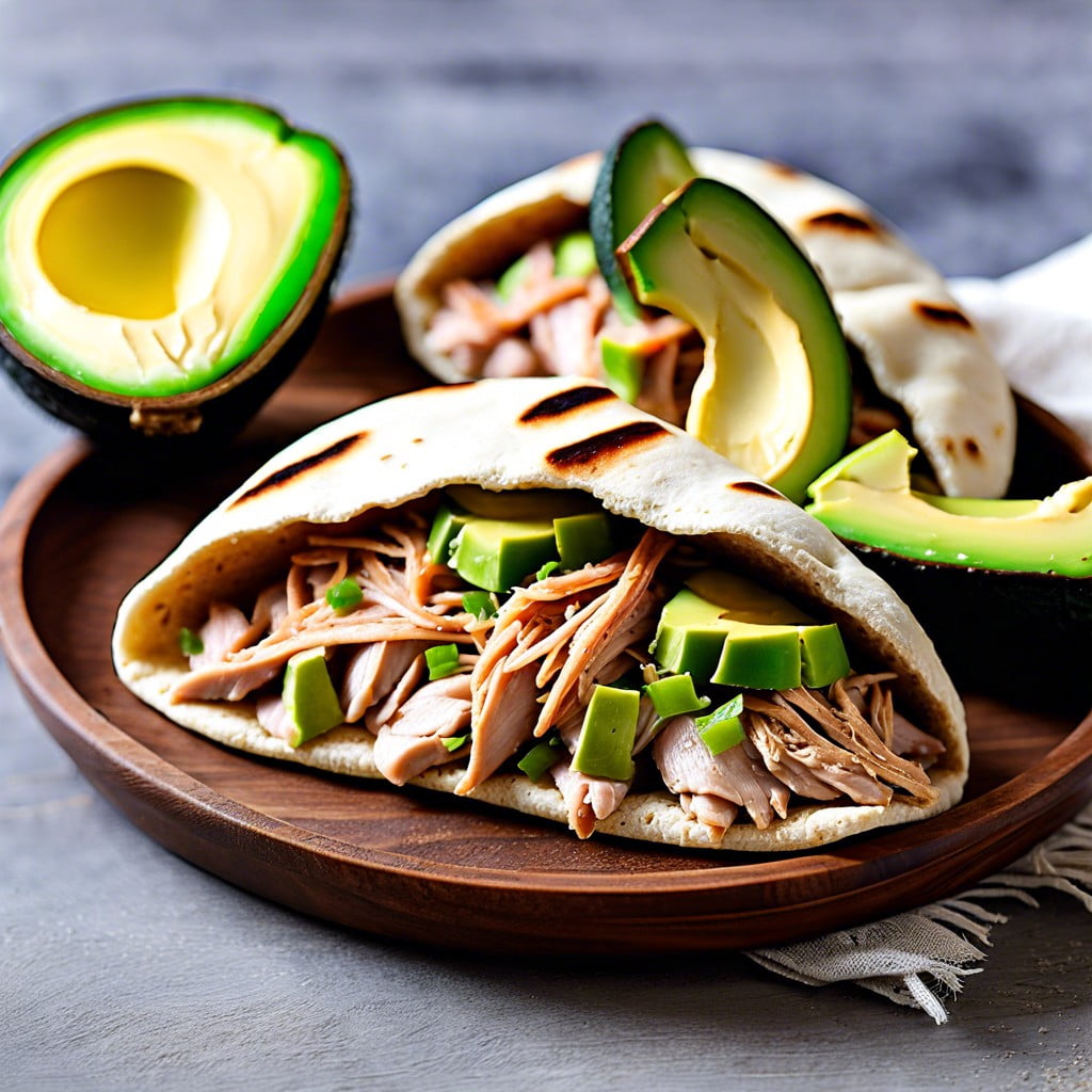 whole wheat pita pockets filled with avocado and shredded chicken